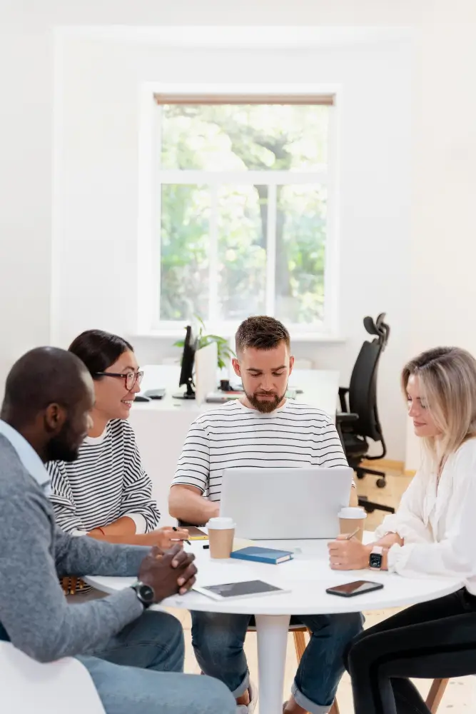 Groupe diversifié de professionnels en réunion autour d’une table